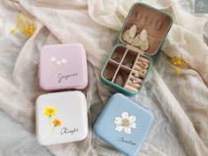 three small tins filled with different types of items on top of a white blanket