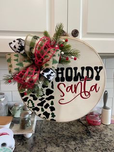 a sign that says holidy santa on the side of a kitchen counter with christmas decorations around it