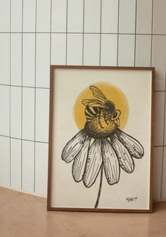 a bee sitting on top of a flower in front of a tiled wall with white tiles