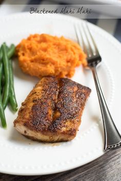 a plate with meat, mashed potatoes and green beans