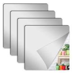 four white frames with plants and potted plants on them