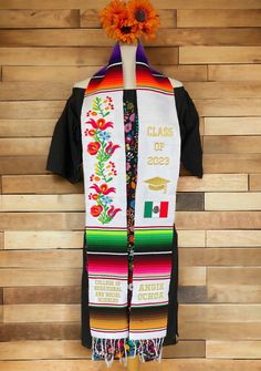 Remember this important phase in your life and look radiant with your Mexican Sarape Stole as apart of your Graduation gown! All details and personalization is embroidered. "No Personalization" option is the stole as is in the photo without names/ school names. "Text Only" option is text added at the bottom two squares on the stole. "Text & Flag" option is text in the bottom two squares and (1) flag. Dimensions: 80 inches Long x 5 inches Wide My shop policies:  - Please read my descriptions thor Mexican Grad Sash, Mexican American Graduation Stole, Peruvian Graduation Stole, Affordable Customizable Graduation Stole, Multicolor Embroidered Graduation Stole, Embroidered Multicolor Graduation Stole, Traditional Embroidered Graduation Stole, Graduation Boards, Graduation Gown