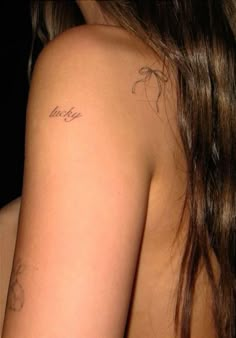 the back of a woman's shoulder with tattoos on her left arm and chest