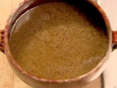 a brown cup filled with liquid sitting on top of a wooden table