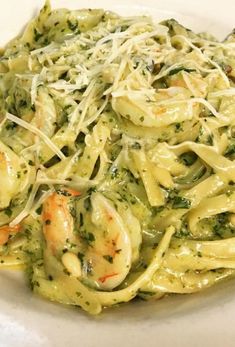 pasta with shrimp, broccoli and parmesan cheese in a white bowl