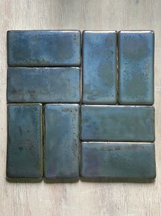 several square blue tiles on a wooden surface