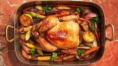 a roasting pan filled with roasted chicken and vegetables