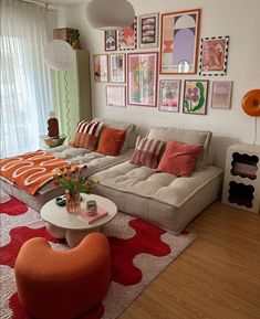 a living room filled with lots of furniture and pictures on the wall above it's couch