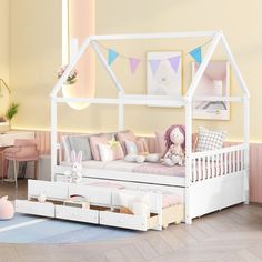 a child's bedroom with a white bed frame and pink pillows on the floor