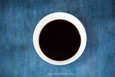 a cup of coffee sitting on top of a blue table