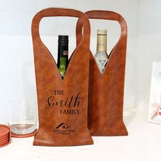 two leather wine bags with bottles in them