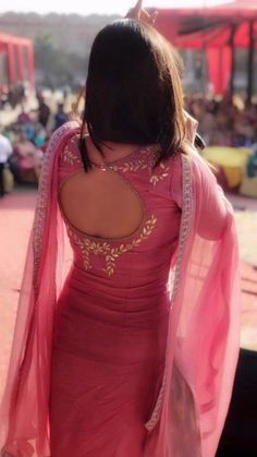 the back of a woman's pink dress and shawl, with people in the background