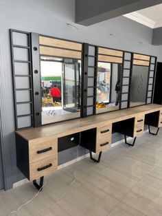 an empty room with mirrors and drawers on the wall