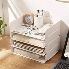 a laptop computer sitting on top of a wooden desk next to a stack of books