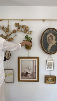 a man standing next to a wall with pictures on it