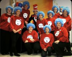 a group of people wearing red shirts and blue wigs