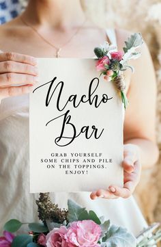 a woman holding up a sign with flowers on it that says macho bar, great yourself some chips and fill on their wedding day