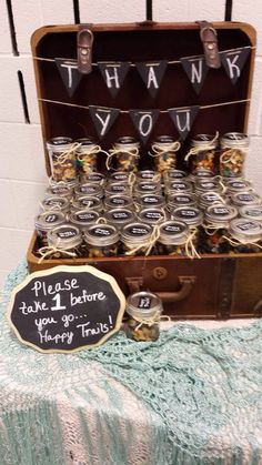 an open trunk filled with mason jars and thank you sign next to a chalkboard