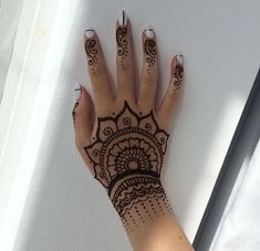 a woman's hand with henna tattoos on it