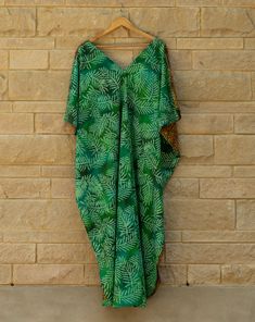 This breathable cotton kaftan combines regal drape with down to earth prints. The rich green and deep yellow and brown palm prints are sure to turn heads at brunch or an outdoor party. The side slits add movement and show off your legs, while the bra savers hold everything in place. All kaftans are handmade in small batches in Austin,TX. Sizes and color may slightly vary due to lighting and screen settings. Green Batik Print Dress For The Beach, Green Vacation Dress With Side Slits, Green Vacation Dresses With Side Slits, Green Dresses With Side Slits For Vacation, Green Batik Print Kaftan, Green Batik Print Kaftan For Beach, Green Bohemian Kaftan With Relaxed Fit, Green Bohemian Relaxed Fit Kaftan, Summer Green Batik Print Kaftan