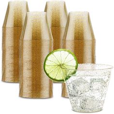 there are four glasses and a lime slice next to each other