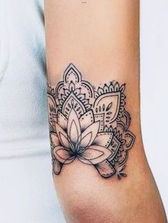 a woman's arm with a flower tattoo on the left side of her arm