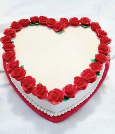 a heart shaped cake with red roses on it