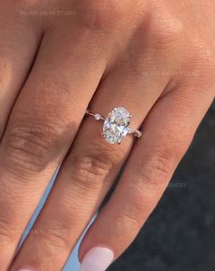 a woman's hand with a ring on her finger and a diamond in the middle