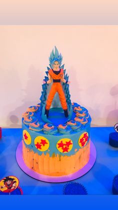 a birthday cake with a dragon ball figure on top and other decorations around the cake