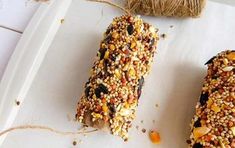 two birdseed bars on a white plate next to twine