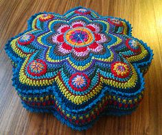 a crocheted cushion sitting on top of a wooden table