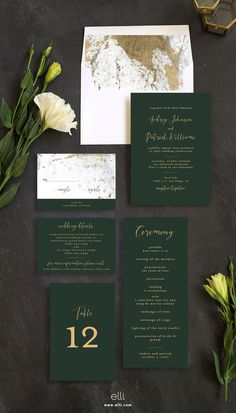 the wedding stationery is set up with flowers and greenery