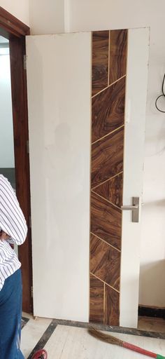 a man sitting on the floor in front of a white wall with wood paneling