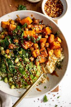 a white bowl filled with rice, broccoli and sweet potato stir - fry