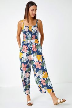 Floral Print Stretch Jumpsuit from Roman. Perfect for warm Spring days, this culotte trouser printed jumpsuit is floaty and feminine. Cut from a smooth woven fabric, this contrast flower print piece features a square neckline with comfortable straps. Its shirred stretch bodice makes it easy to pull on, whilst a self tie belt cinches you in at the middle. The trousers fall to the shin in a floaty cropped culotte style. Pair with sandals and a denim jacket to complete the casual Summer look! Culotte Style, Stretch Jumpsuit, Warm Spring, Blue Floral Print, Floral Jumpsuit, Printed Jumpsuit, Linen Dresses, Fashion Face, Tie Belt