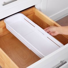 a person is opening the drawers in a kitchen