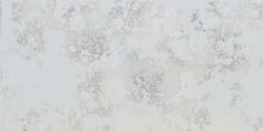 a white marble textured wall with some brown spots