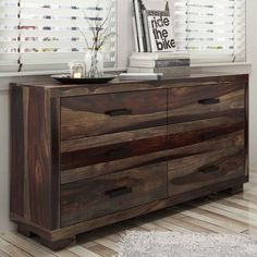 a wooden dresser sitting in front of a window