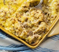 a casserole dish with meat and cheese in it on a blue and white towel