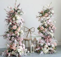 two archways decorated with pink and white flowers next to a small table lamp on the floor