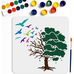 a tree with birds flying over it next to paintbrushes and watercolors