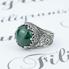 Elevate Your Style with Our Malachite Gemstone Filigree Art Silver Crown Ring Indulge in the perfect combination of elegance and craftsmanship with our Malachite Gemstone 925 Sterling Silver Artisan-Made Handcrafted Filigree Art Crown Ring. This isn't just a piece of jewelry; it's a work of art, exuding the timeless allure of intricate lace details. At the heart of this masterpiece is a mesmerizing Malachite gemstone, boasting a 12 mm cabochon round cut. Known for its vibrant green hues and believed to possess protective and transformative energies, Malachite is a gemstone that symbolizes growth and renewal, making it an exquisite addition to your collection. When you choose this ring, you're not just purchasing jewelry; you're investing in a symbol of beauty and grace. Each piece is metic Gemstone Crown, Art Crown, Metal Embroidery, Silver Crown Ring, Silver Cocktail, Filigree Jewelry, Silver Crown, Crown Design, Crown Ring