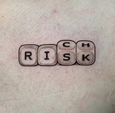 a person with a scrabble tattoo on their chest