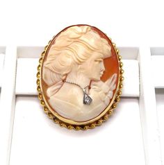 14k Yellow Gold Cameo Diamond Brooch pendantBeautiful detailed carving on her hair and flowers on her dressClasp and pendant hoop in good working conditionStamped: "14k" inside of the rimMeasures approx. 1 1/2" long X 1 1/4" wide or 3.9 cm X 3 cmOutside rim measures approx. 2 mm wide - Twisted ropeDiamond is approx: .02 ctTotal weight: 8.1 gFEEL FREE TO MESSAGE ME WITH A BEST OFFER!041315-4070Please contact me if you are interested in purchasing multiple items, I am happy to negotiate and accomm Elegant Carved Gold Brooches, Carved Yellow Gold Brooches For Wedding, Elegant Carved Brooches For Gifts, Elegant Yellow Gold Intaglio Brooches, Elegant Yellow Gold Brooches With Intaglio, Elegant Yellow Gold Intaglio Brooch, Carved Brooches For Formal Occasions, Yellow Gold Brooches For Anniversary, Anniversary Oval Brooches