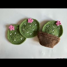 three crocheted cactus coasters sitting on top of a table