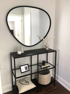 a black shelf with a round mirror on it