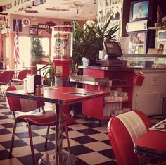 a restaurant with checkered floor and red chairs