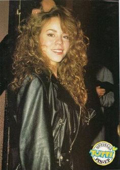 a woman with curly hair wearing a black leather jacket