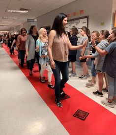 a group of people standing on top of a red carpeted floor next to each other