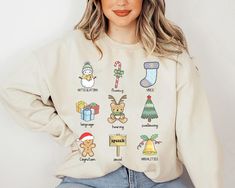 a woman wearing a sweatshirt with christmas icons on it and her hands behind her back